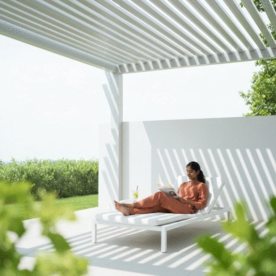 User enjoying outdoor living space with a louvered pergola