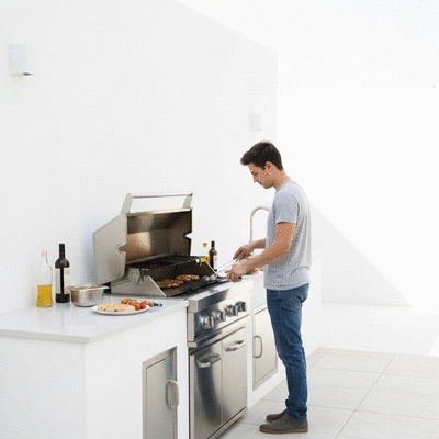 User grilling in an outdoor kitchen